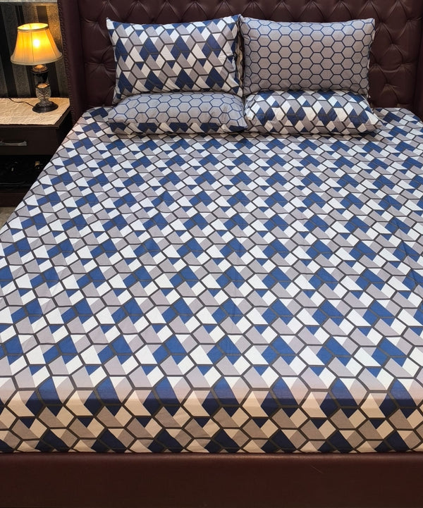 Bed with geometric patterned bedding and pillows in a bedroom setting.