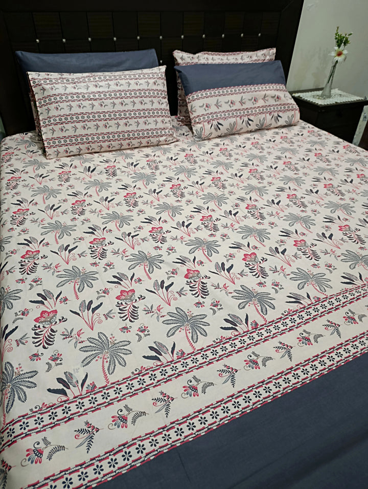 Floral palm tree bedding on a bed with blue accents